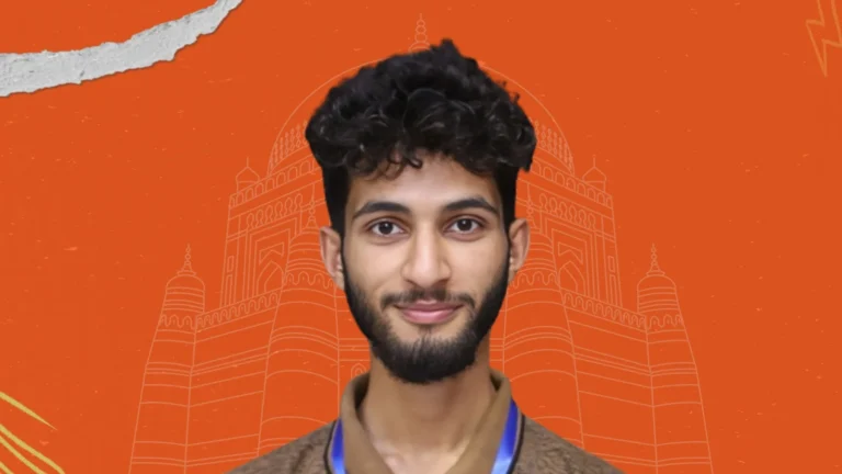 Young man with curly hair smiling in front of Multan landmark on orange background