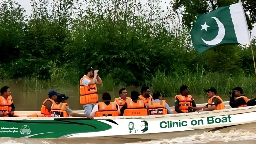 A medical team on a boat in Punjab, Pakistan, offering healthcare services in flood-affected areas with a waving Pakistani flag.