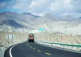 Development in Pakistan showing road construction with mountains in background