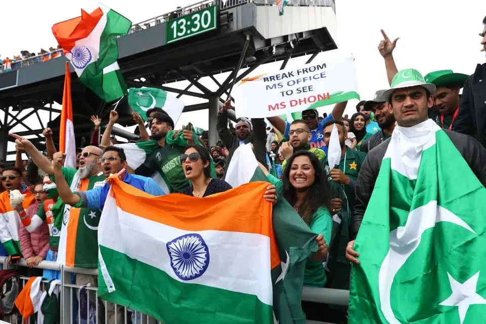 Cricket fans from Pakistan and India cheering with flags ahead of Asia Cup 2025 final in Dubai stadium