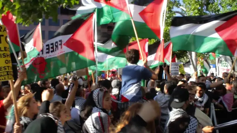 People waving flags and celebrating in G@za after announcement of peace plan and ce@sefire agreement