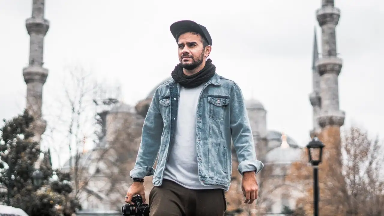 Pakistani YouTuber Irfan Junejo walking outdoors with a camera, symbolizing his journey from Karachi to Barcelona after interviewing FC Barcelona players