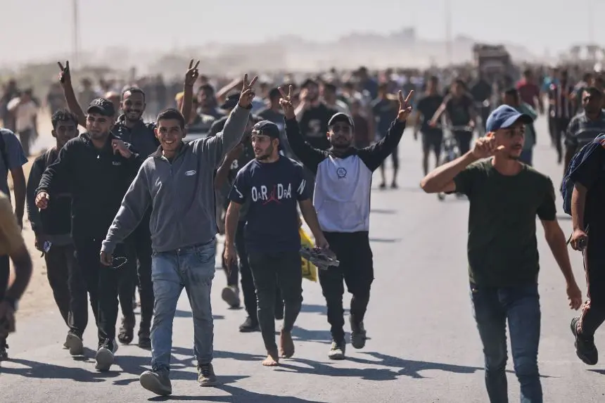 Displaced Palestinians walking back to northern Gaza with raised victory signs after Israel’s partial withdrawal