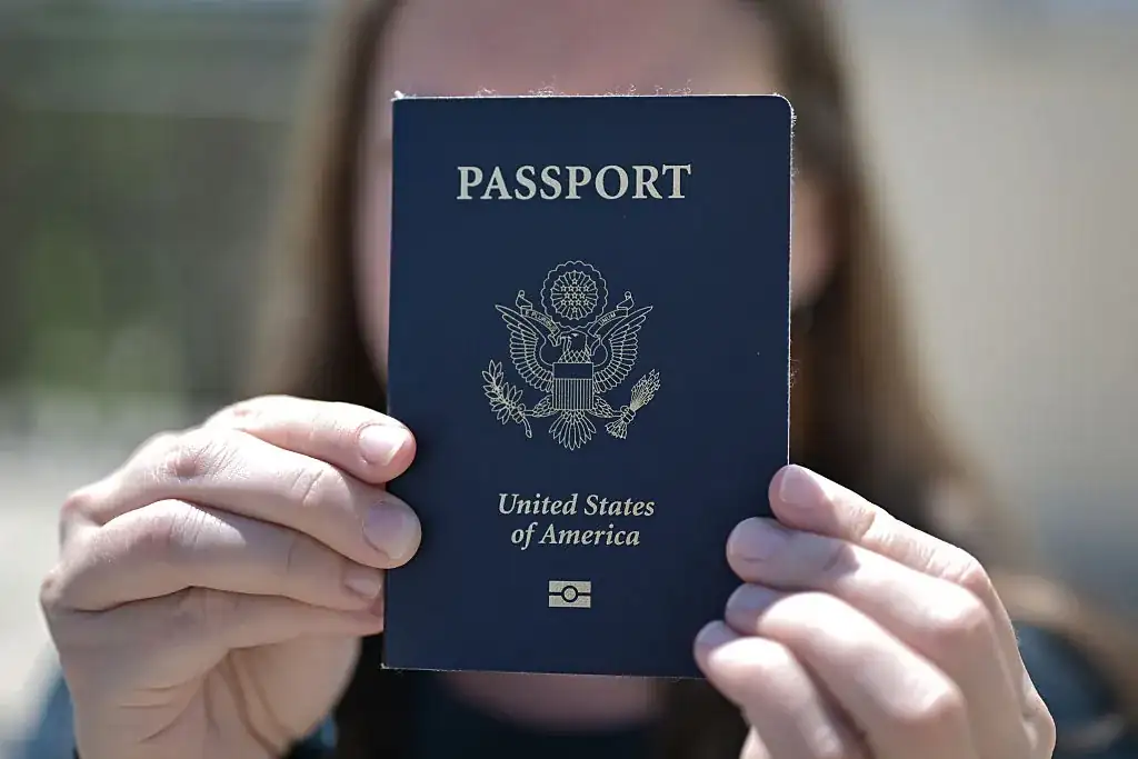 Person holding a United States passport representing the drop in the US passport ranking for 2025.