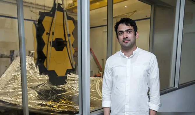 Pakistani engineer Yasir Tufail standing beside NASA’s James Webb Space Telescope model at a research facility