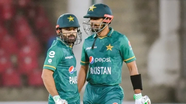Two Pakistani cricketers in green uniforms during an ODI match, used for the Babar Rizwan ICC rankings article.