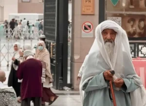 Elderly blind man standing with a walking stick near the Prophet’s Mosque in Madinah