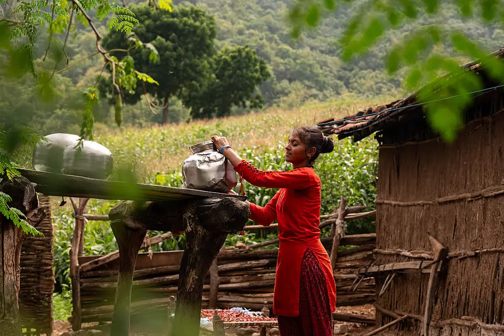Indian village girl collecting water in drought affected area showing impact of drying wells on education