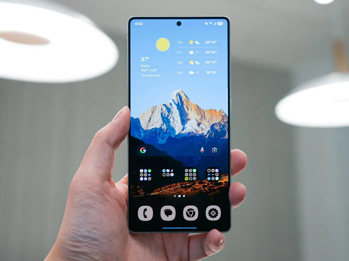 A person holding a smartphone showing a mountain wallpaper, used to represent the Made in Pakistan Phone and secure communication technology.