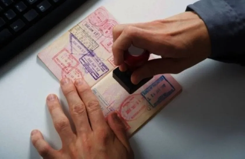Passport being stamped, representing Oman's new cultural visa for skilled individuals in creative and heritage fields.