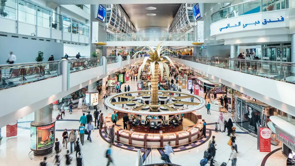 Busy interior of Dubai International Airport showing travelers and duty free area, used for the Pakistan Dubai Airport passenger traffic news article.