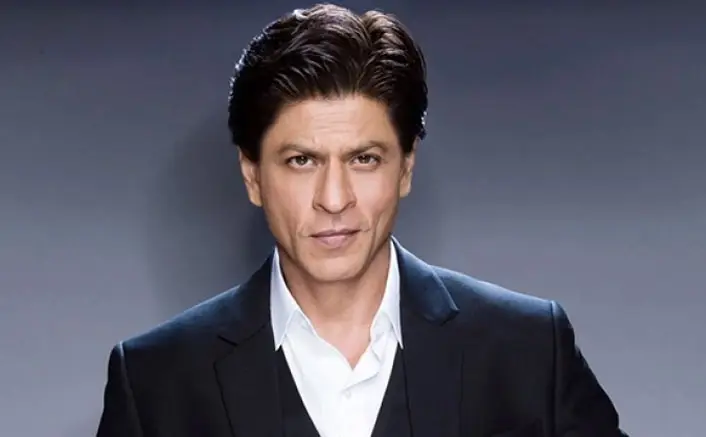 Shah Rukh Khan in a formal suit, representing the announcement of a Dubai skyscraper named in his honor.