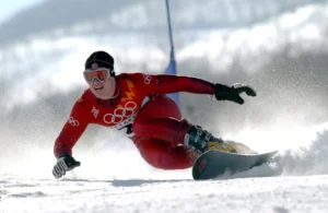 A former Olympic snowboarder in action, showcasing athleticism during a race.