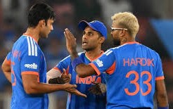 Indian cricket players in blue celebrating a wicket against Netherlands at the Narendra Modi Stadium during T20 World Cup 2026, showcasing intense match action.