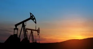 Oil pumpjack silhouette at sunset representing oil prices fluctuations in global energy market