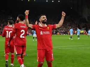 Liverpool players celebrating a goal at Anfield during Premier League results clash