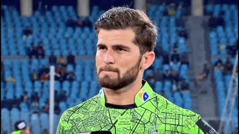 Shaheen Shah Afridi sitting on the field in Pakistan team uniform, reflecting during a match amid PCB hotel security concerns.