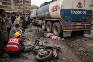 Karachi accident showing oil tanker and motorcycle crash scene in Nazimabad with rescue workers and bystanders