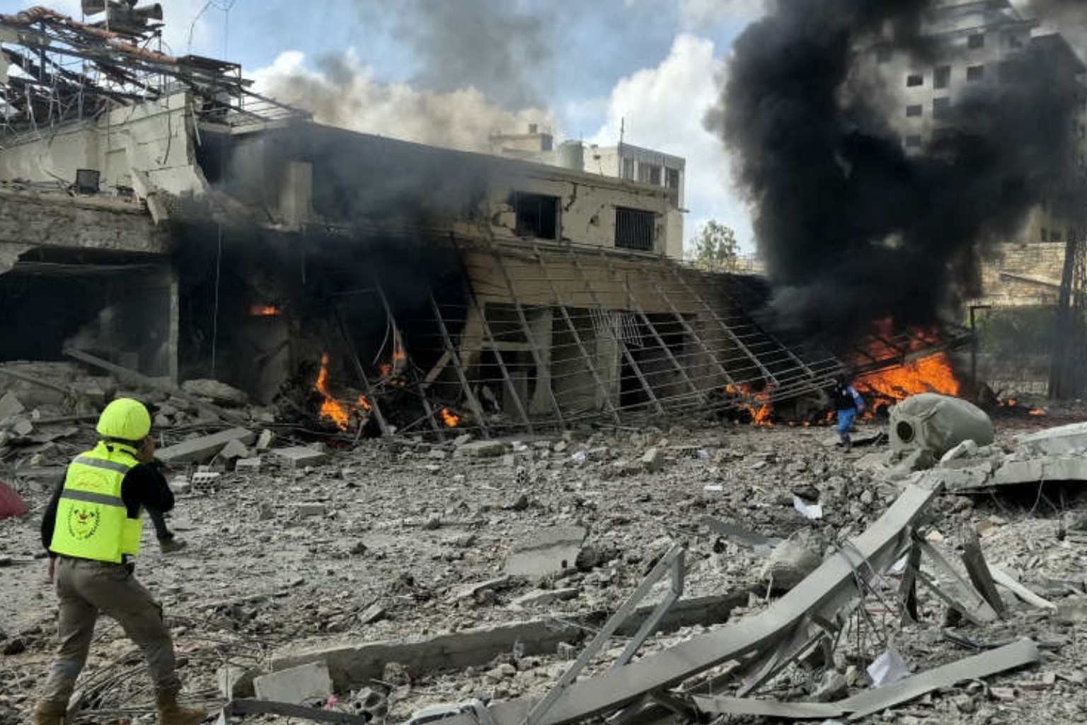 A high-quality photo showing smoke and destruction at a strike site in Lebanon, highlighting the urgent need for a Lebanon ceasefire.