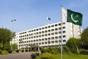 Ministry of Foreign Affairs building in Pakistan with Pakistani flag, surrounded by landscaped gardens and clear blue sky
