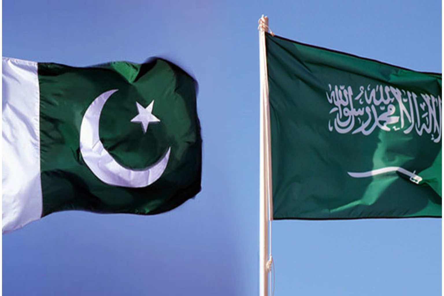 A high-quality image of the Pakistani and Saudi Arabian flags flying together against a clear blue sky, illustrating the strategic Pakistan-Saudi cooperation.