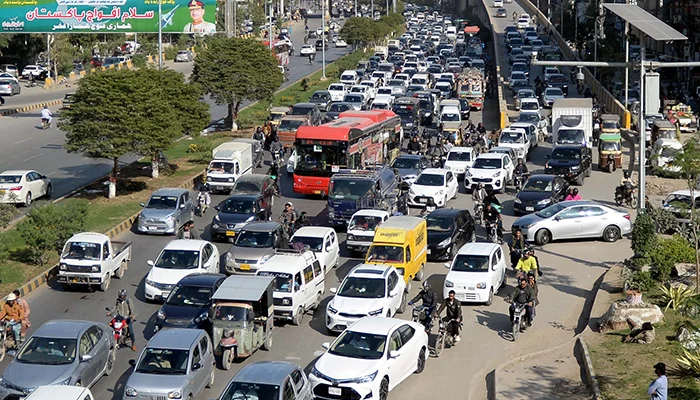Traffic congestion on Sharea Faisal Karachi showing motorbikes, buses, and rickshaws following designated Karachi traffic lanes rules
