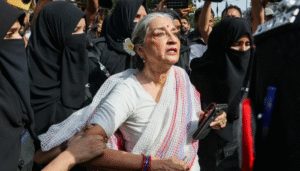 Women police officers detaining activist Sheema Kermani and Aurat March Karachi organizers outside the Press Club.