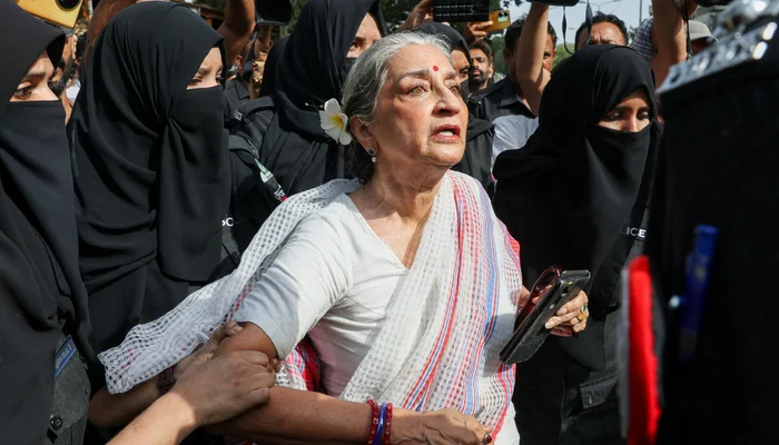 Women police officers detaining activist Sheema Kermani and Aurat March Karachi organizers outside the Press Club.
