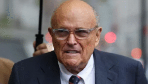 A news broadcast graphic reporting on former NYC Mayor Rudy Giuliani hospitalized in critical but stable condition.