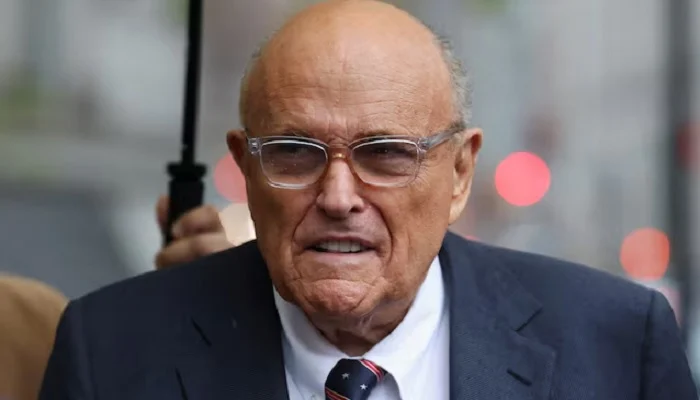 A news broadcast graphic reporting on former NYC Mayor Rudy Giuliani hospitalized in critical but stable condition.