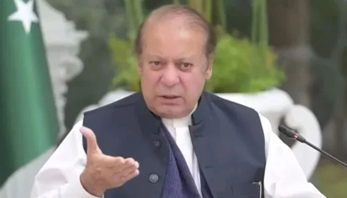 Former Prime Minister of Pakistan and PML-N leader Nawaz Sharif speaking at a microphone with the Pakistani flag visible in the background.