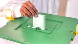 AJK elections voting process showing a voter casting a ballot during the election.