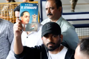 Cockroach Janta Party founder holding a book while arriving in New Delhi to participate in a youth protest against the government.