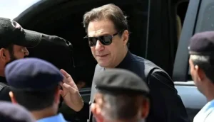 Imran Khan wearing sunglasses speaking to security personnel while arriving or leaving for his fifth eye injection treatment at PIMS hospital