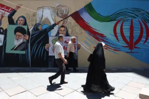 People walk past a mural featuring Iranian national symbols and political imagery in Tehran during discussions over the Iran US Deal.