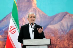Iranian official speaking at a podium during discussions related to the Iran US deal and ongoing nuclear negotiations.