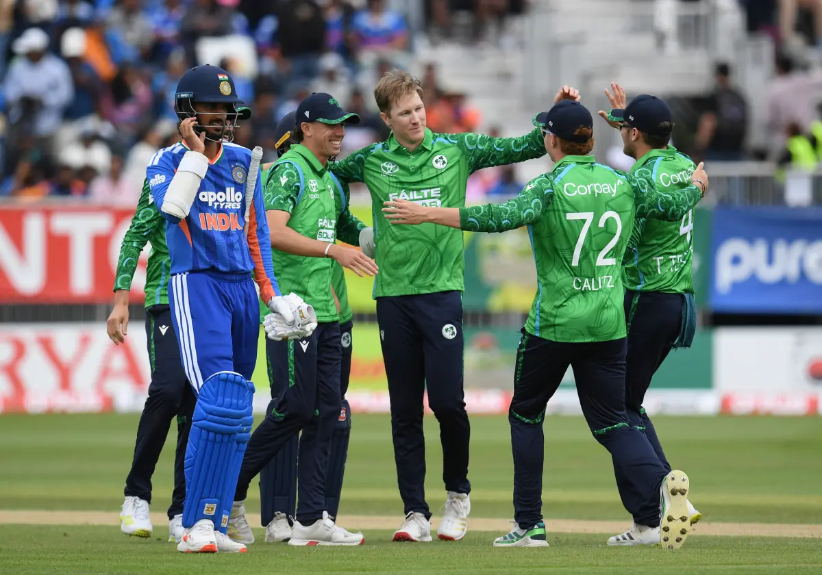 Ireland players celebrate after defeating India in the Ireland India T20 series at Belfast while an Indian batter walks away.