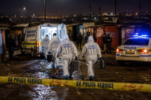 Forensic investigators and police officers examine the Johannesburg Shooting crime scene at an informal settlement in South Africa.