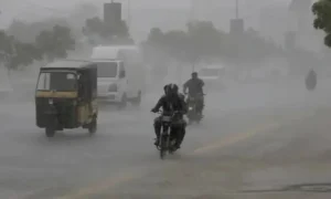 Vehicles including rickshaw and motorcycles moving through heavy rain and dust storm in Karachi streets under PMD Karachi Rain Forecast