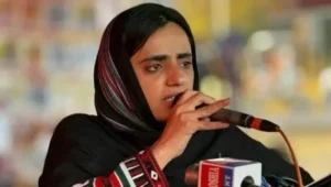 Dr Mahrang Baloch speaking into a microphone at a public gathering after receiving a life imprisonment sentence in the Gwadar protest case