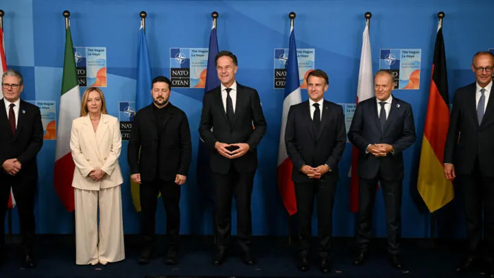 NATO leaders and Ukrainian President Volodymyr Zelensky pose during a summit meeting as NATO Spending commitments increase.