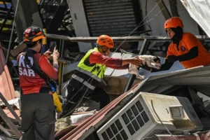 Rescue workers search through earthquake debris in Mindanao during the Philippines Earthquake recovery operation.