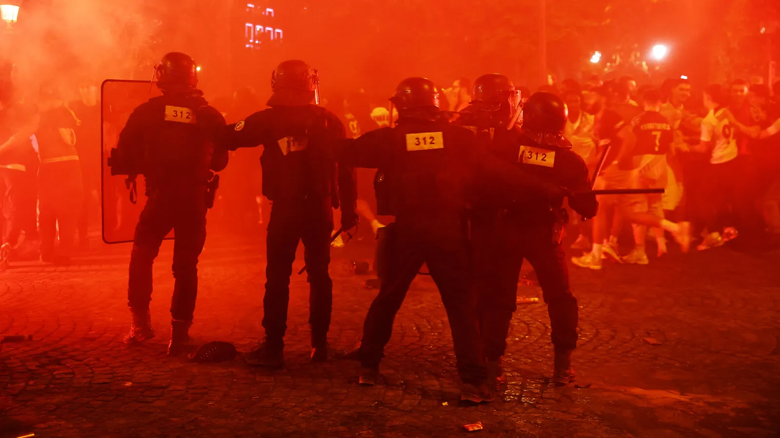 French police officers confront crowds during PSG Clashes after Paris Saint Germain's Champions League victory celebrations in Paris.