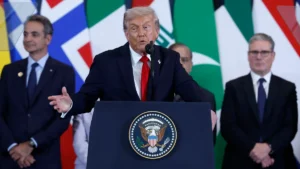 Donald Trump delivers a speech during an international event as Trump Iran tensions remain high amid ongoing peace talks in Switzerland.