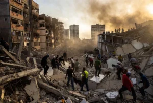 Dramatic view of collapsed buildings and rescue teams searching through rubble after the powerful Venezuela earthquakes in La Guaira, showing the urgent humanitarian response following the deadly twin quakes.