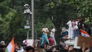 Crowds gather near an AI powered police surveillance camera during the AI surveillance protest in New Delhi.