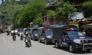 AJK Security with police vehicles deployed on a road in Azad Jammu and Kashmir to maintain law and order during heightened security concerns.