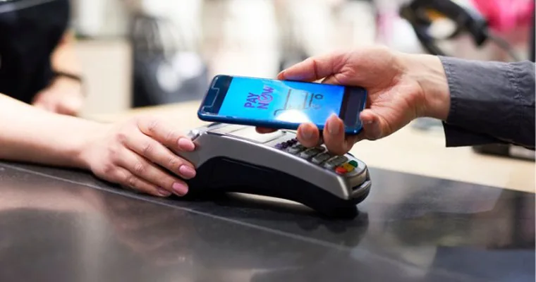 Customer making a contactless smartphone payment at a POS terminal, highlighting Digital Payments growth in Pakistan.