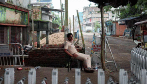 A police officer sits at a security checkpoint in an urban area while barricades and restricted roads are visible during heightened security measures.