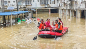 Rescue workers evacuate residents by inflatable boat through flooded streets during China Storms caused by severe rainfall and flooding.